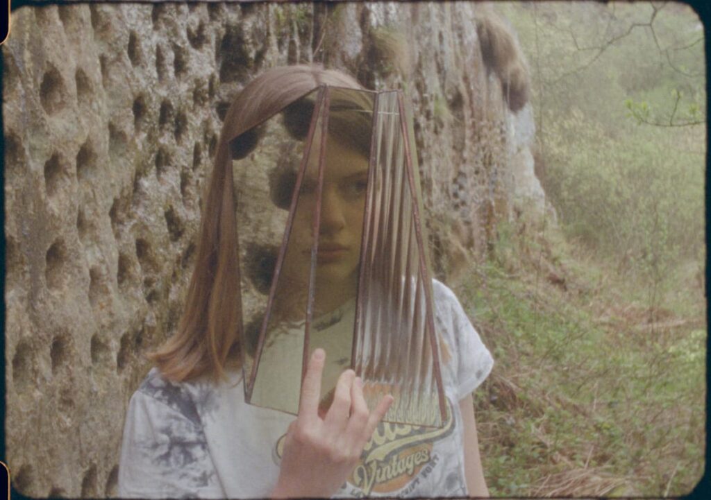 A girl holding glass in front of her face